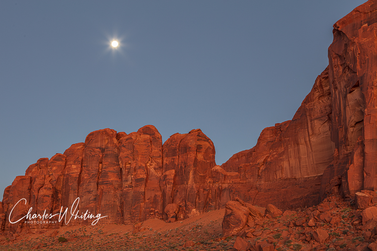 The full moon shines above the red buttes