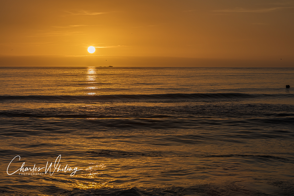 A boat heads home during the last light of day